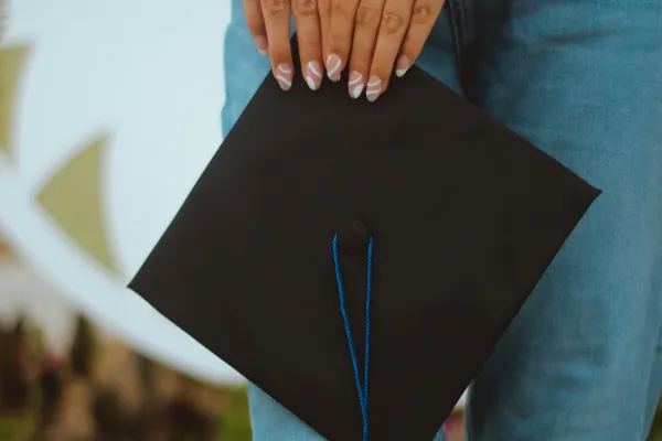 Person holding graduation cap