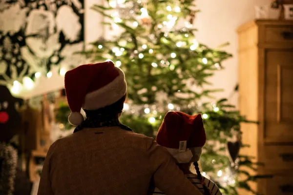 Two People sitting in front of christmas tree