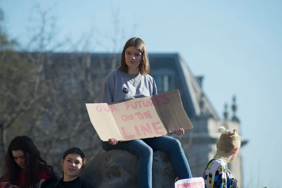 Woman holding sign that reads "Our future's on the line"