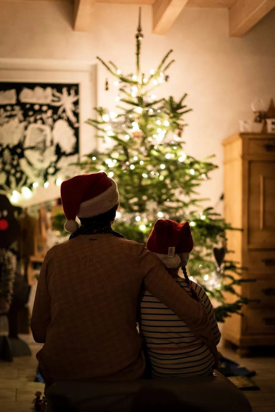 Two People sitting in front of christmas tree